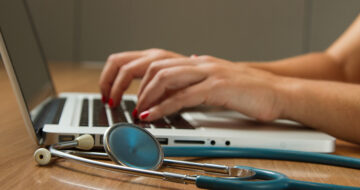 A medical professional entering patient data on laptop computer. Photo courtesy of the National Cancer Institute.